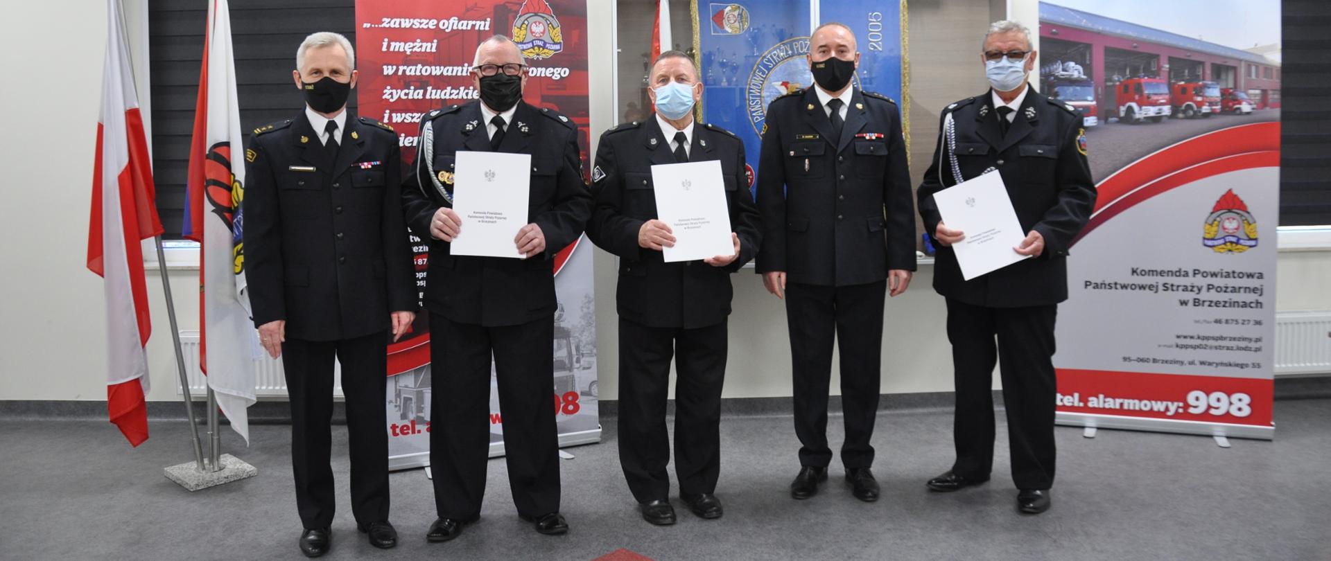 Na zdjęciu Komendant Powiatowy PSP w Brzezinach oraz jego Zastępca oraz trzech druhów OSP odbierających świadczenie ratownicze.