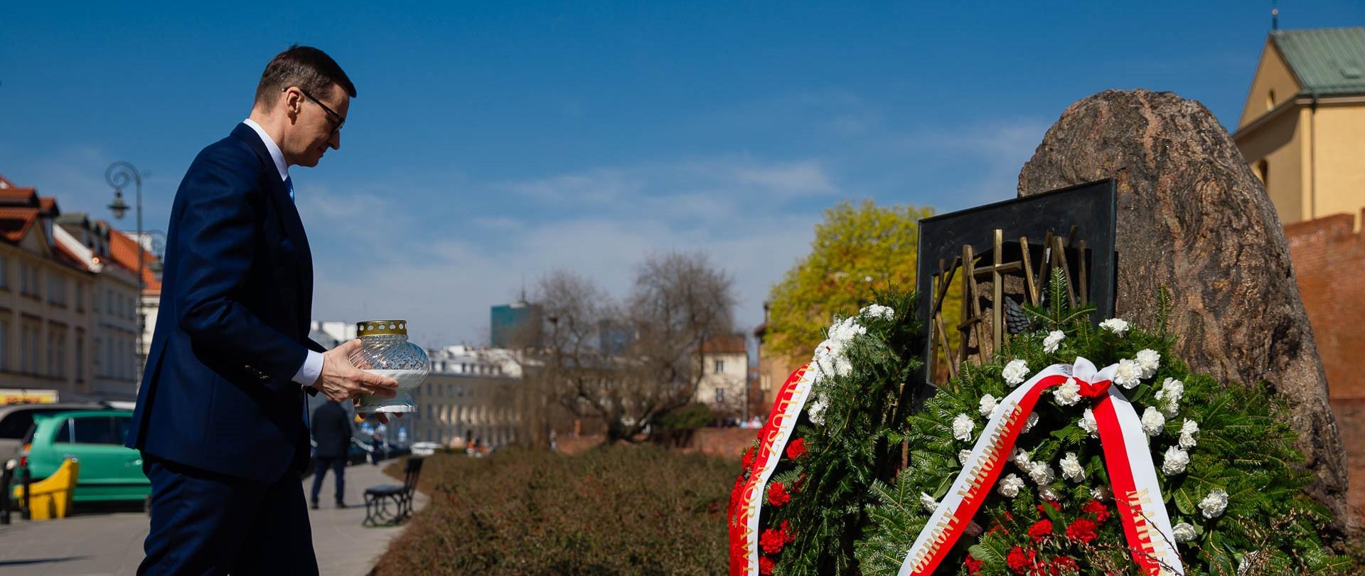 Premier Mateusz Morawiecki zapala znicz przed pomnikiem Katyńskim