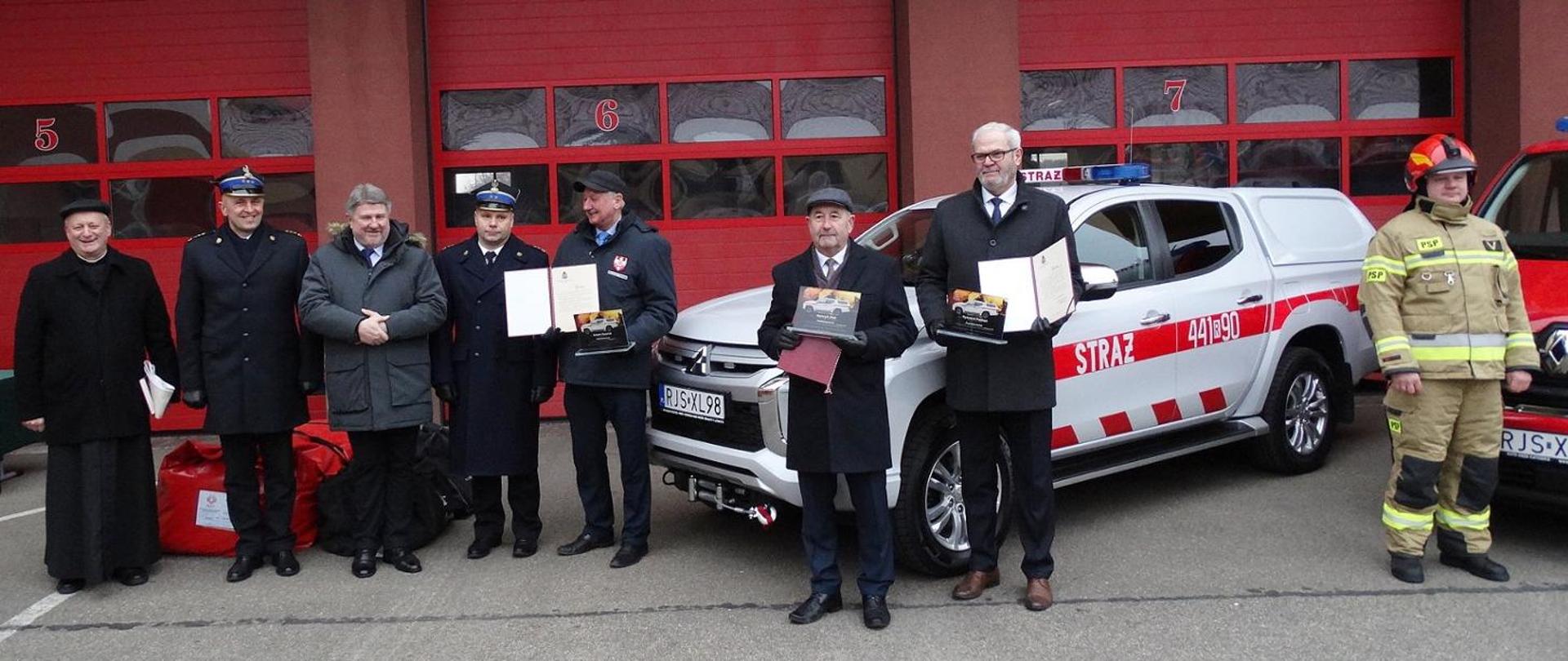 Na zdjęciu na tle nowych samochodów zaproszeni goście pierwszy od lewej : ksiądz Zbigniew Irzyk dziekan Dekanatu Jasło Wschód,starszy brygadier Daniel Dryniak zastępca podkarpackiego komendanta wojewódzkiego , Bogdan Rzońca Poseł do Parlamentu Europejskiego, brygadier Piotr Śmietana, Adam Pawluś starosta jasielski, Henryk Rak przewodniczący Rady Miasta Jasła, Ryszard Pabian burmistrz Miasta Jasła