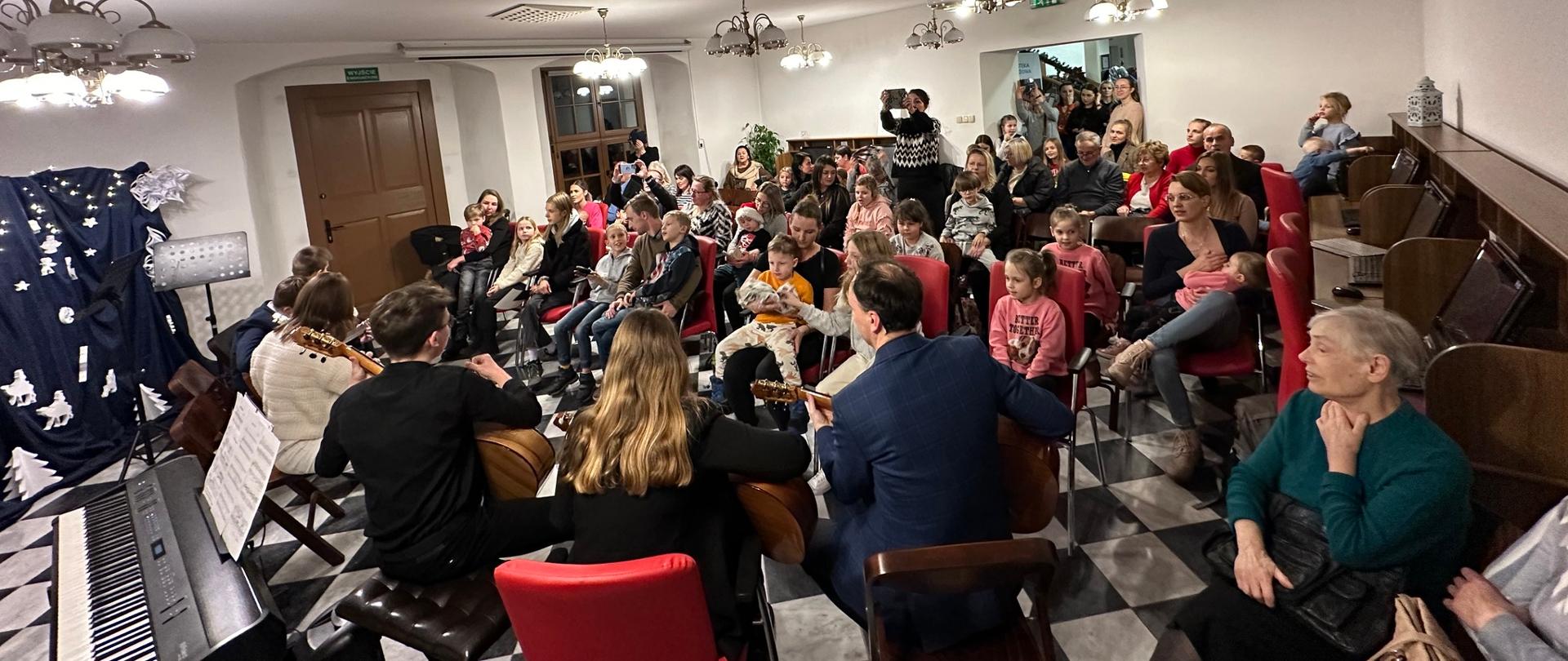 Występ zespołu gitarowego w czytelni Biblioteki Miasta i Gminy we Wschowie.