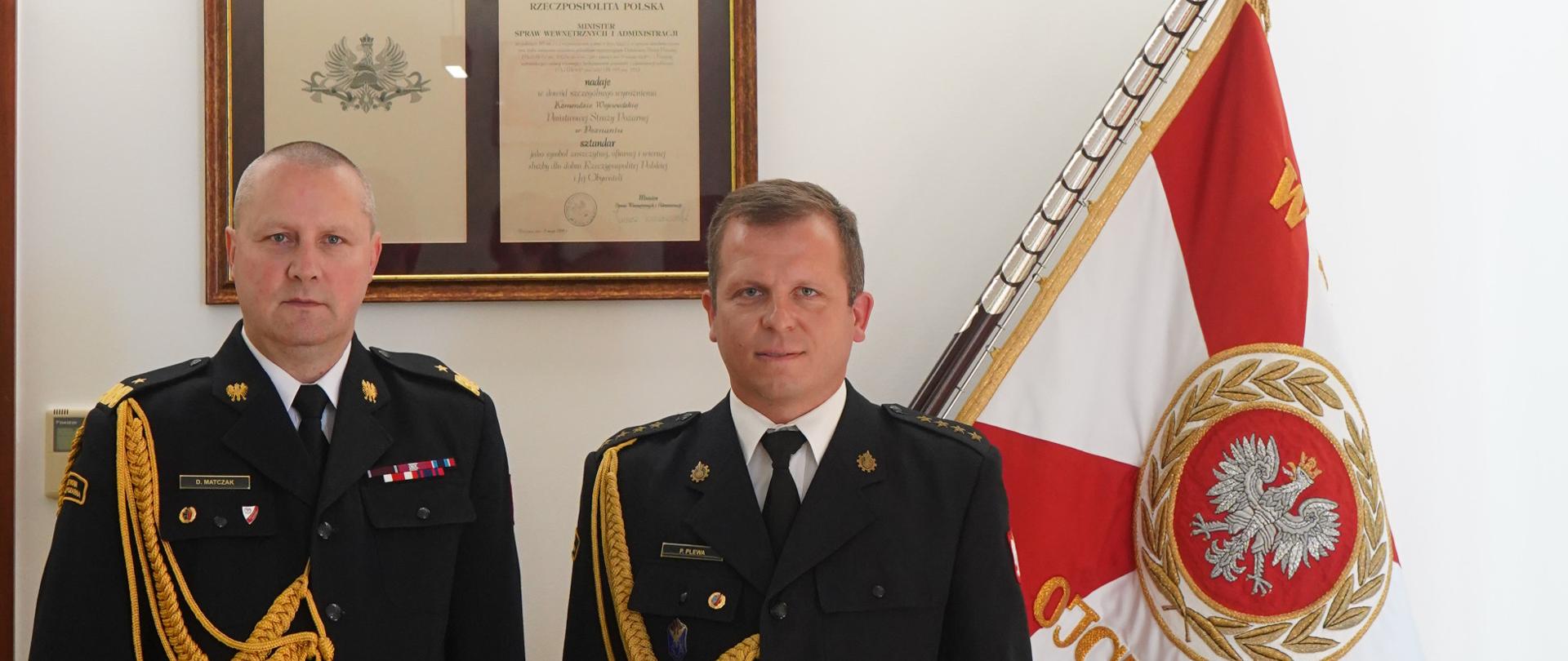 Dwie osoby w mundurach stoją w szeregu.