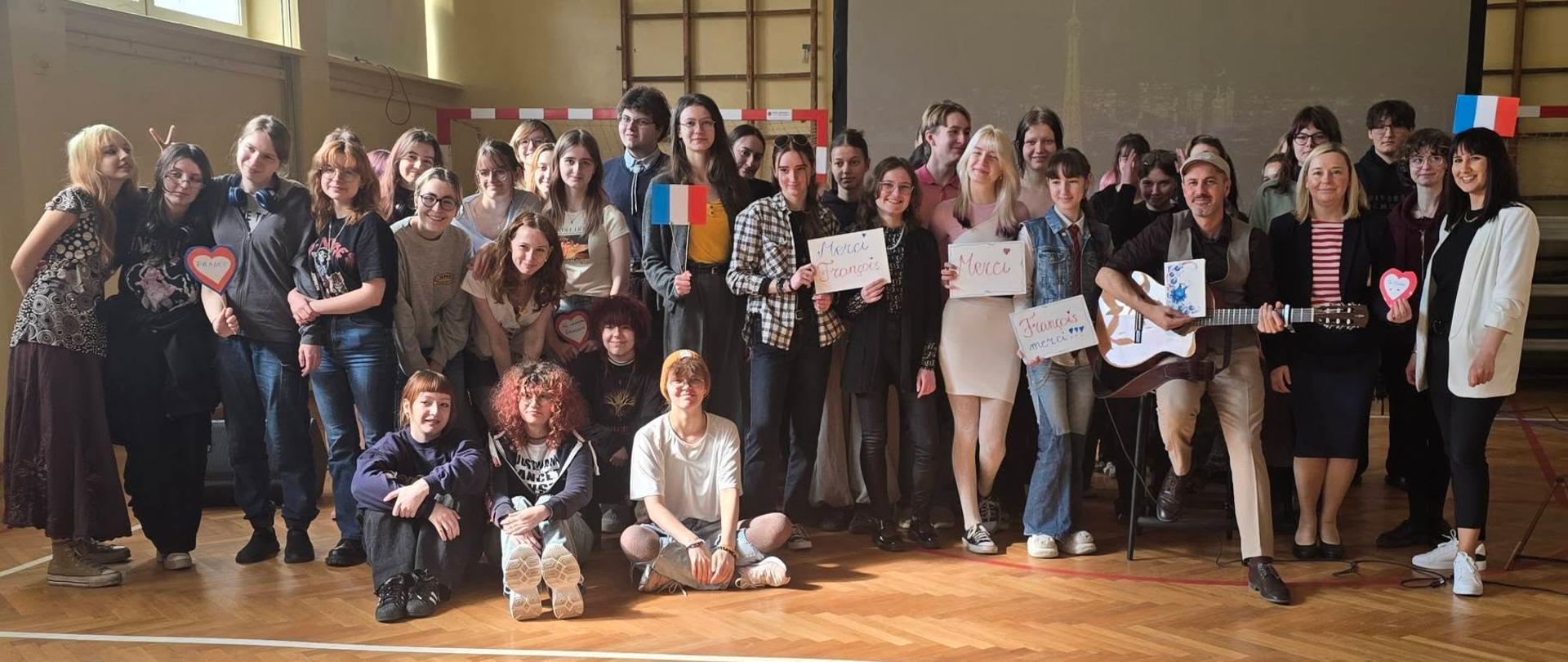 Zdjęcie zbiorowe uczniów w piosenkarzem i gitarzystą François Martineau 