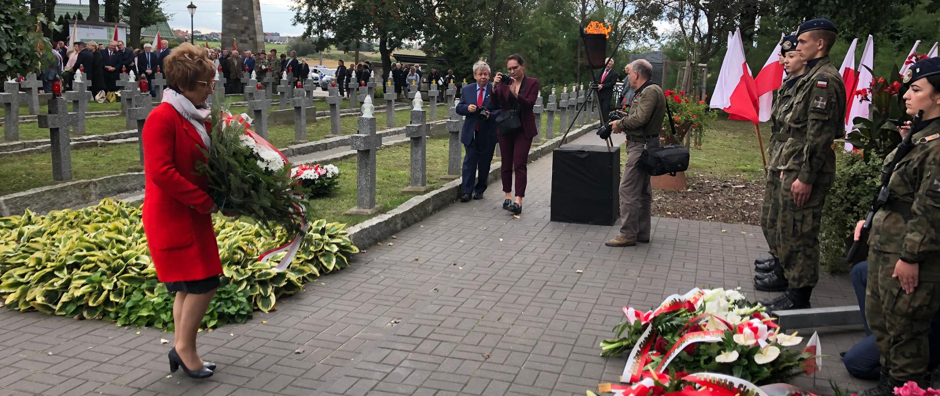 Na zdjęciu widoczna jest kobieta z wiazanką