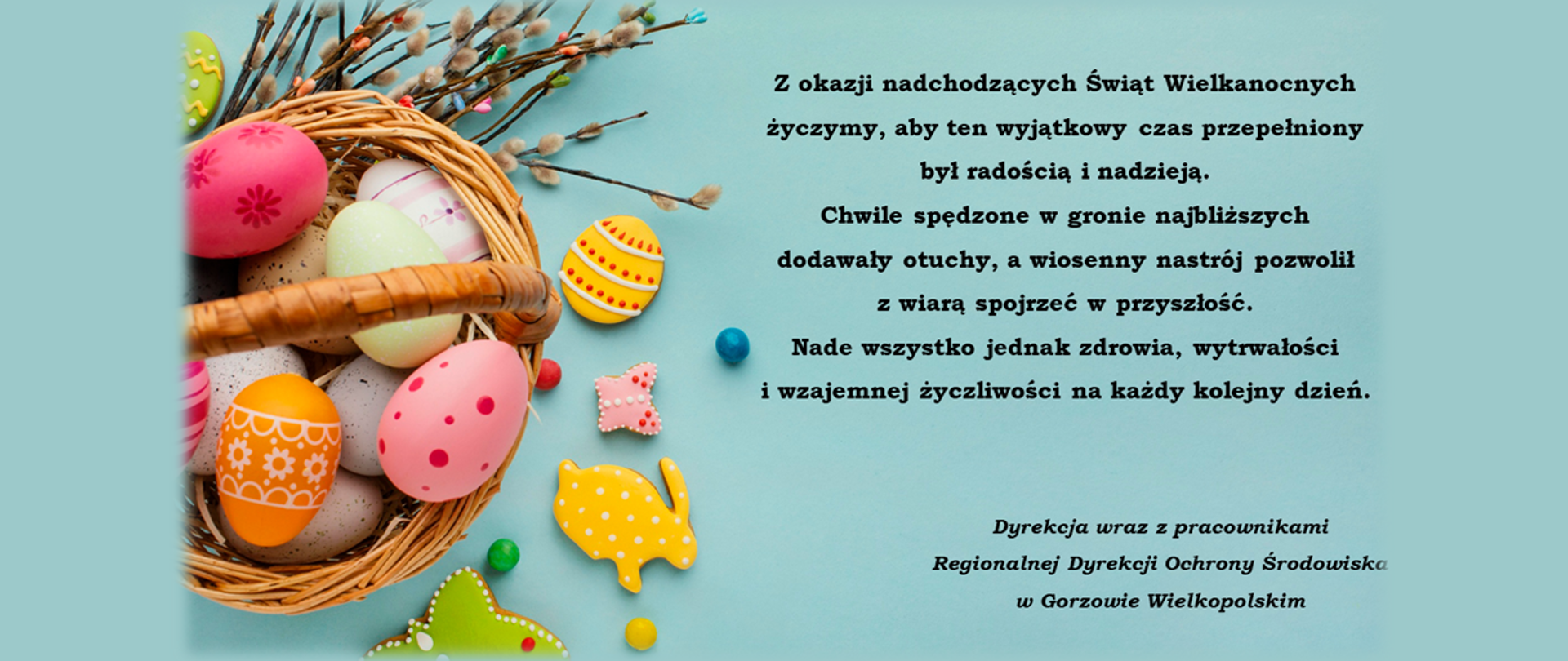 Po lewej stronie koszyczek z pisankami oraz bazie, a po prawej stronie tekst życzeń: Z okazji nadchodzących Świąt Wielkanocnych życzymy, aby ten wyjątkowy czas przepełniony był radością i nadzieją.
Chwile spędzone w gronie najbliższych dodawały otuchy, a wiosenny nastrój pozwolił z wiarą spojrzeć w przyszłość.
Nade wszystko jednak zdrowia, wytrwałości i wzajemnej życzliwości na każdy kolejny dzień.
