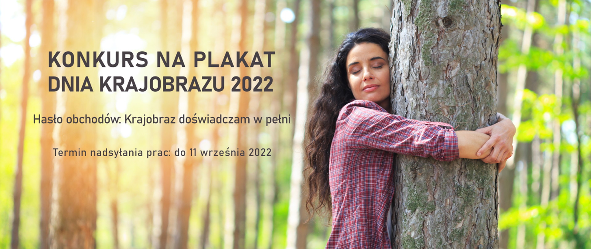 Na pierwszym planie kobieta z długimi włosami obejmuje drzewo. Napis: Konkurs na plakat Dnia Krajobrazu 2022 Hasło obchodów Krajobraz doświadczam w pełni. 