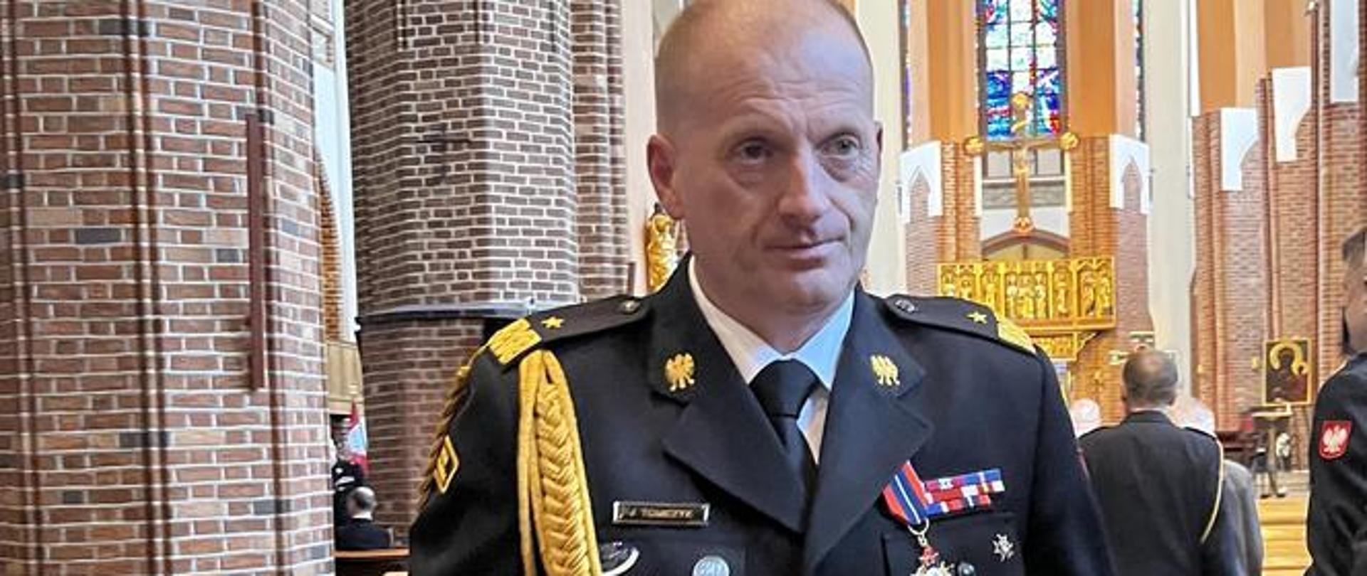 nadbryg. Jarosław Tomczyk, w tle ołtarz katedry