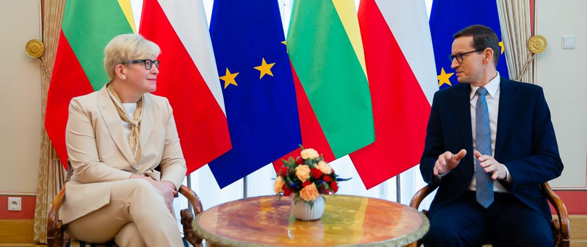 Premier oraz premier Litwy siedzą i rozmawiają przy stoliku.