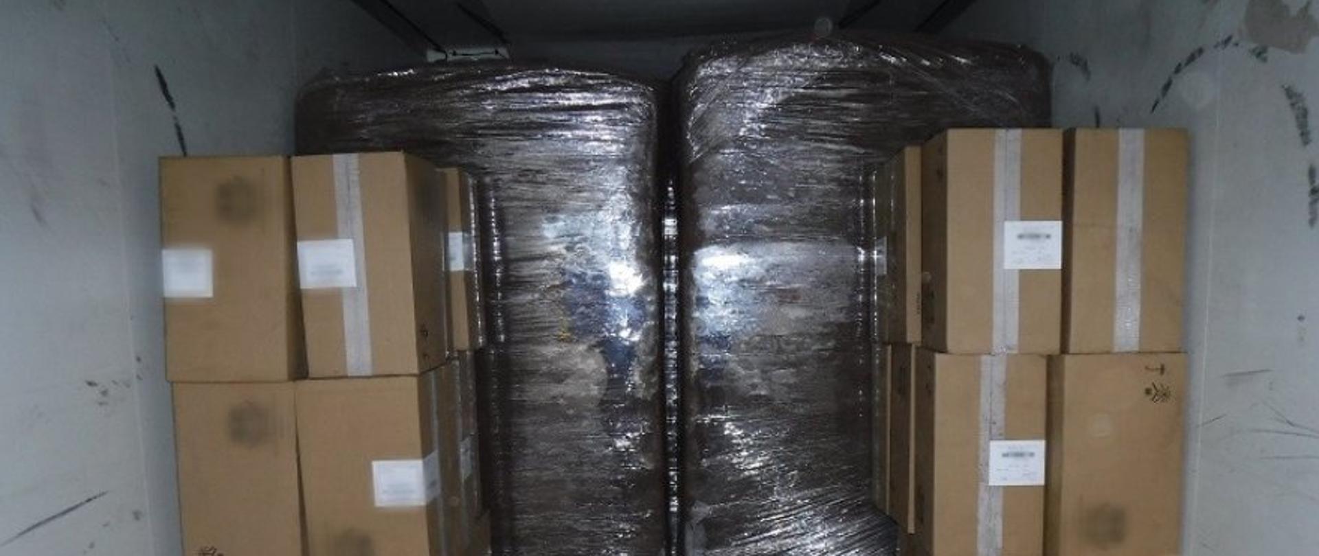 Wnętrze przestrzeni ładunkowej samochodu ciężarowego, widoczne kartony z nielegalnymi papierosami.