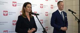 Pani Minister Sportu Danuta Dmowska-Andrzejuk i Prezes Zarządu Totalizatora Sportowego Olgierd Cieślik stoją razem przy mikrofonach. W tle ścianka konferencyjna Ministerstwa Sportu.
