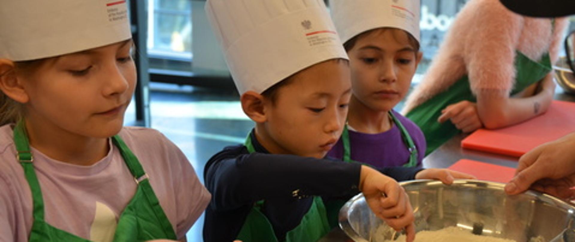 Picture of four children preparing dough for dumplings in big bowls 