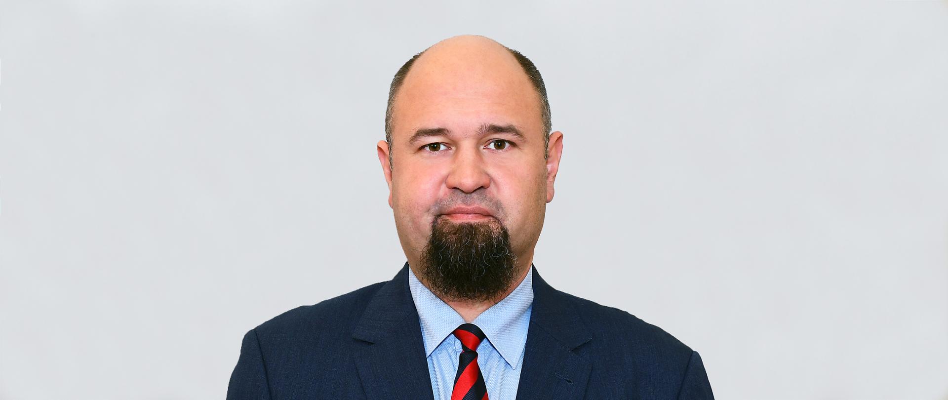 Członek Rady Piotr Lewko w garniturze.