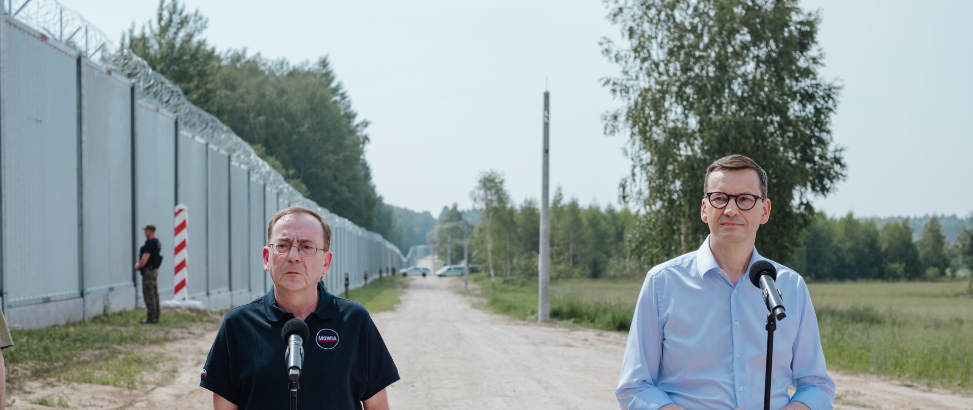 Premier Mateusz Morawiecki i minister spraw wewnętrznych i administracji Mariusz Kamiński podczas konferencji prasowej przy zaporze granicznej po odprawie z funkcjonariuszami Straży Granicznej