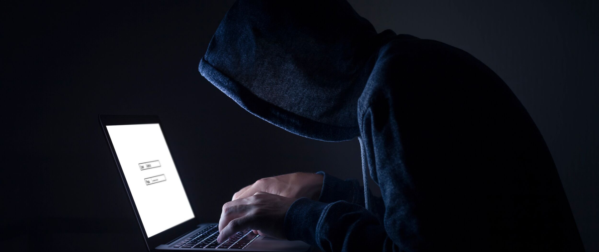 Mężczyzna w kapturze z laptopem