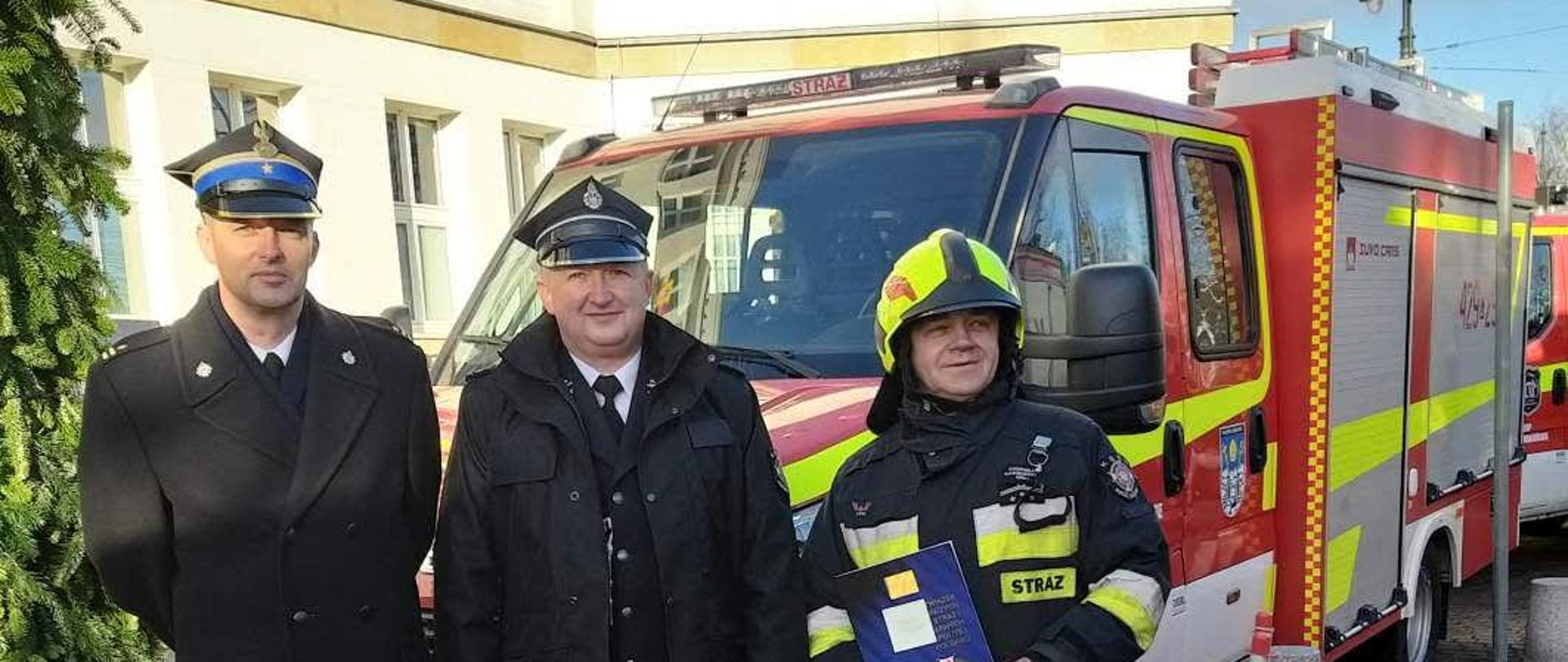 Przekazanie i poświecenie pojazdów w Urzędzie Marszałkowskim w Toruniu, na zdjęciu mł. bryg. Tomasz Guzek - Komendant Powiatowy PSP w Chełmnie oraz dwóch druhów z OSP Papowo Biskupie.