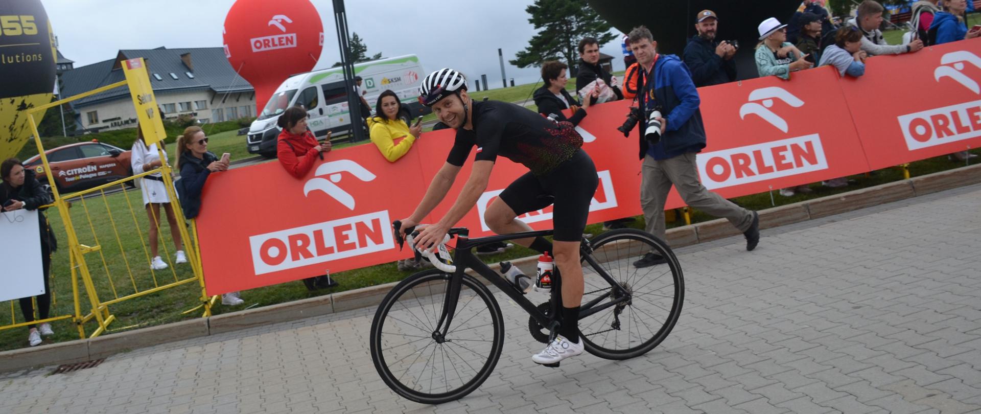 Kolarz na rowerze wjeżdża na metę zawodów