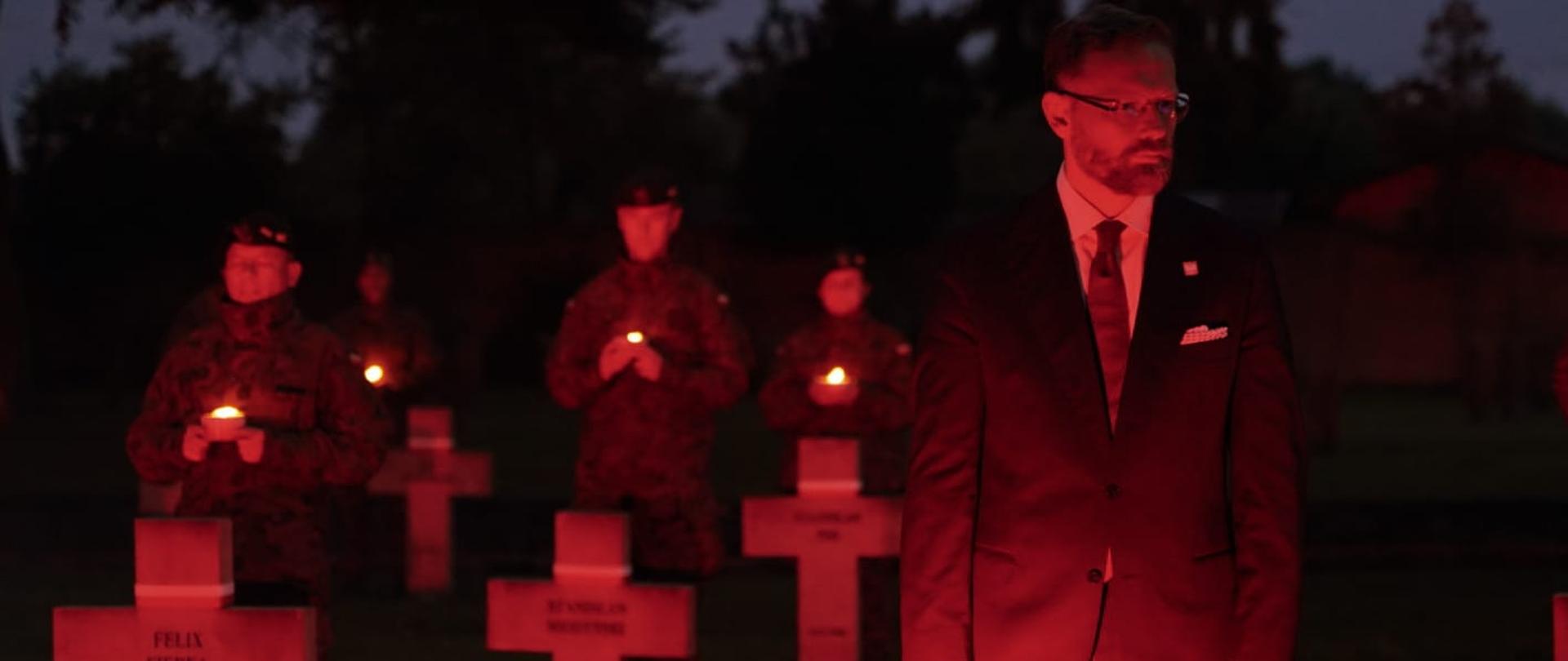 wojewoda Zbigniew Bogucki na tle krzyży na grobach żołnierzy 