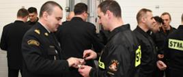 Komendant Wojewódzki PSP przełamuje się opłatkiem ze strażakiem z JRG 2 Olsztyn. 
