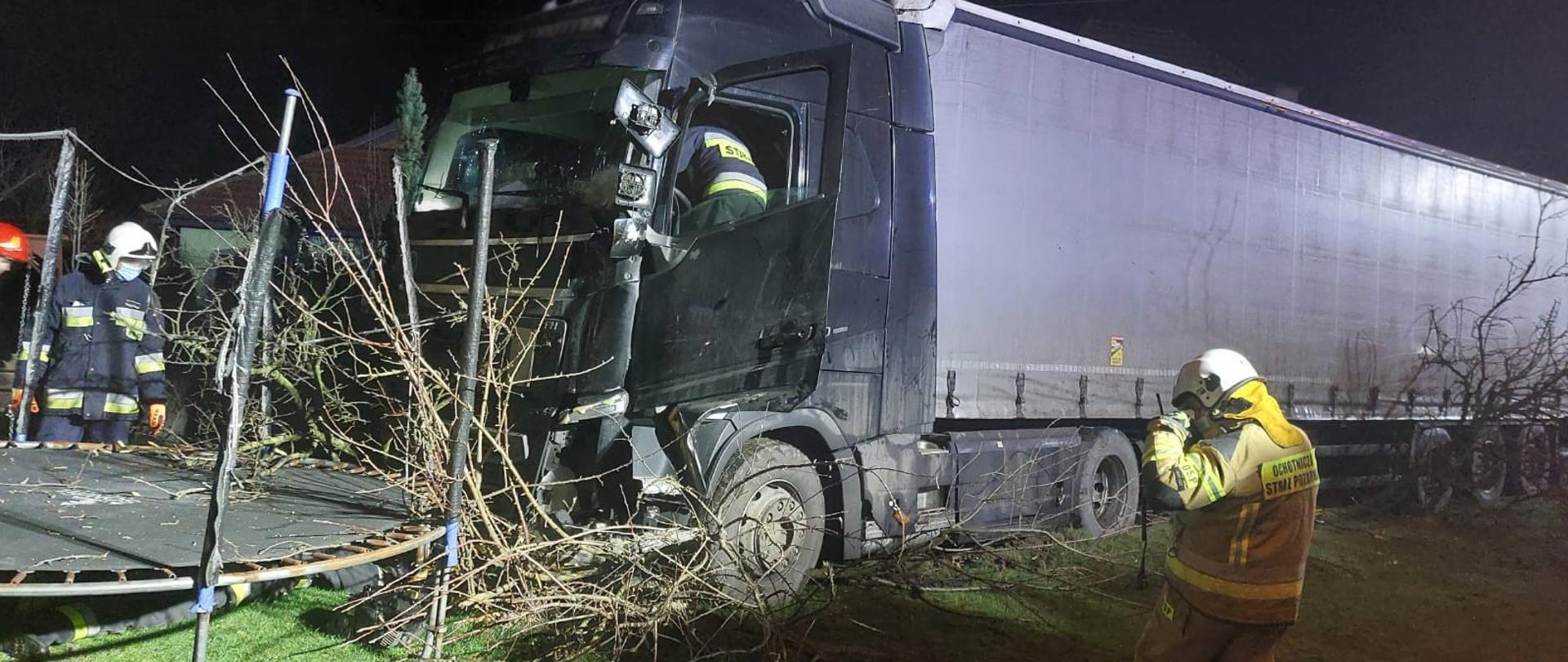 Samochód ciężarowy w ogrodzie a przed nim trampolina