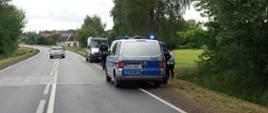 Radiowozy ITD i Policji typu furgon stoją na poboczu drogi.