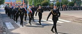 Przemarsz sztandarów i pozostałych funkcjonariuszy na mszę do kościoła.