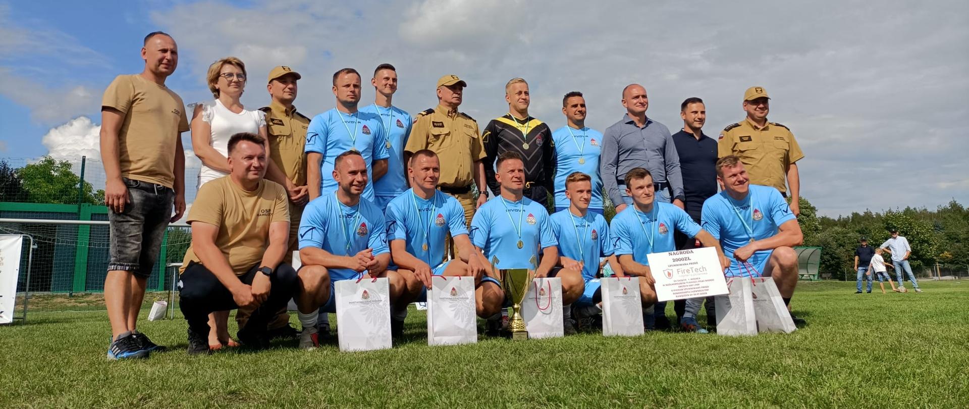Strażacy z medalami i dyplomami po wygranej.