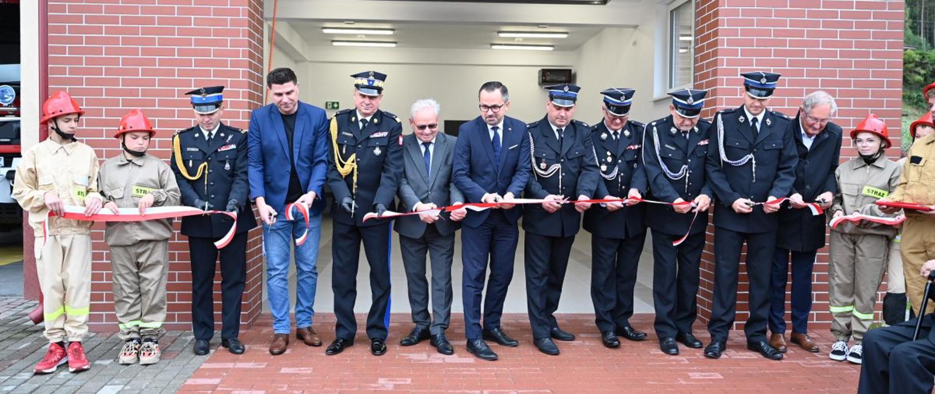 Przecięcie wstęgi przy nowym garażu w rozbudowanej strażnicy.