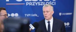 Minister Tomasz Siemoniak przemawia do mikrofonów prasowych 