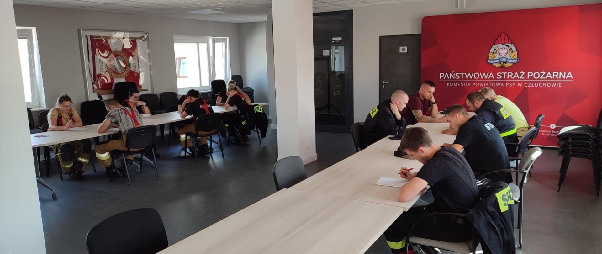 Druhny i druhowie piszą egzamin teoretyczny na sali szkoleniowej w Komendzie Powiatowej Państwowej Straży Pożarnej w Człuchowie. 
