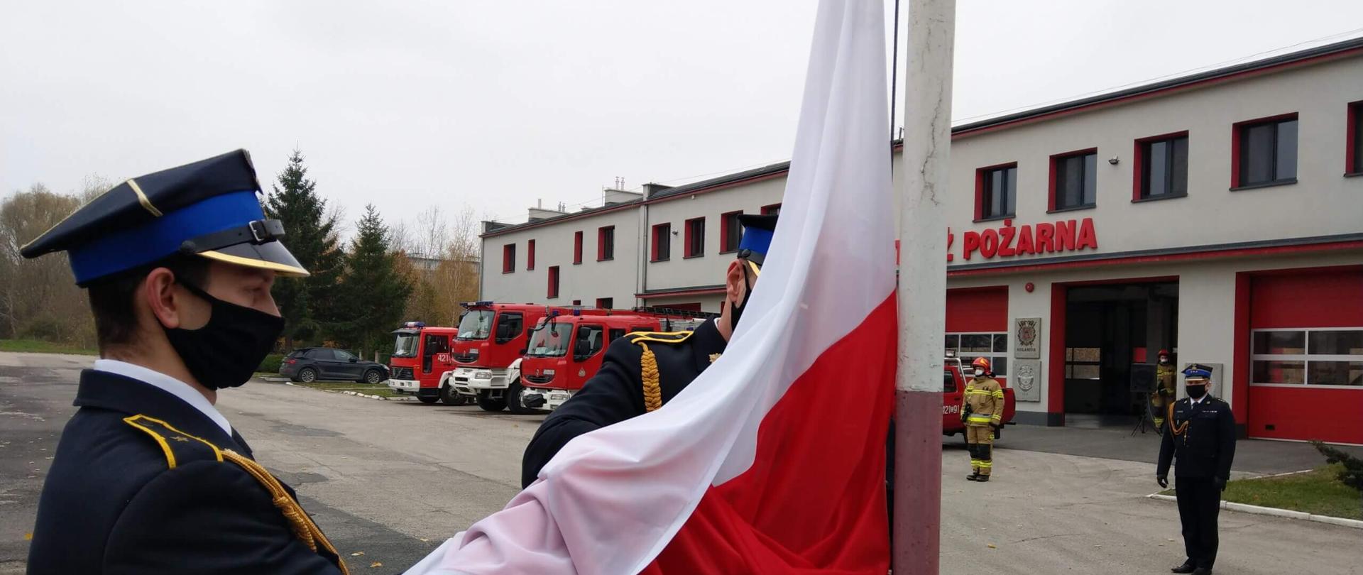 Widnieje poczet flagowy KP PSP Chełmno który wciąga flagę państwową na maszt. Akcja dzieje się przed budynkiem Państwowym KP PSP Chełmno