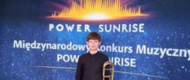 Uczeń na tle baneru konkursu Power Sunrise
