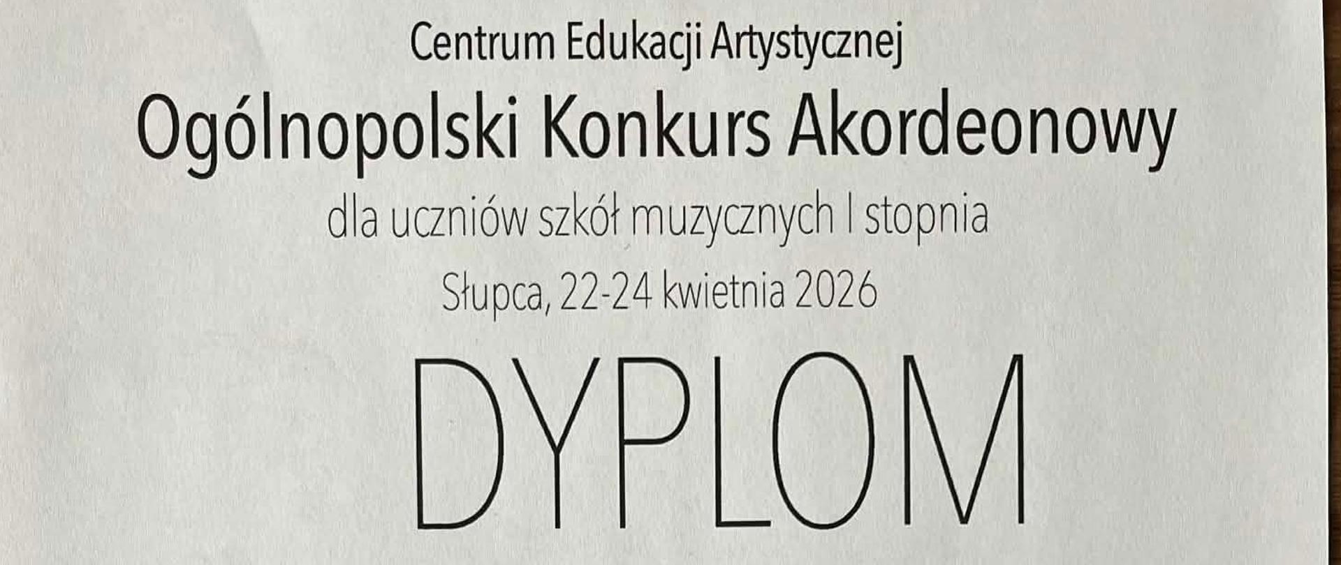 Na białym tle czarnymi literami dyplom uczennicy. Na dole rysunek akordeonu z orłem w koronie i kolorową aurą.