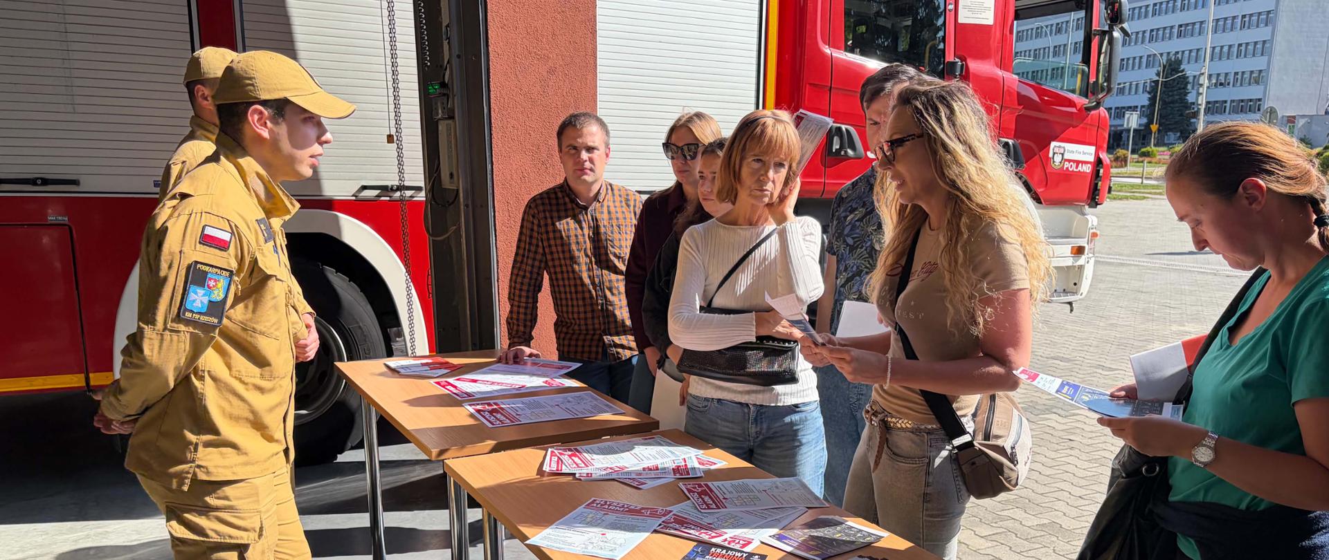 Zdjęcie przedstawia strażaków i osoby, które zapoznają się z akcją dotycząca treningu reagowania