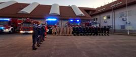 Zdjęcie przedstawia funkcjonariuszy straży, Policji oraz pracowników ratownictwa medycznego podczas oddawania hołdu zmarłemu strażakowi.