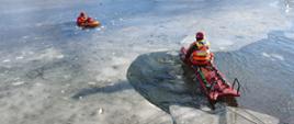 Strażak na saniach lodowych podejmuje poszkodowanego
