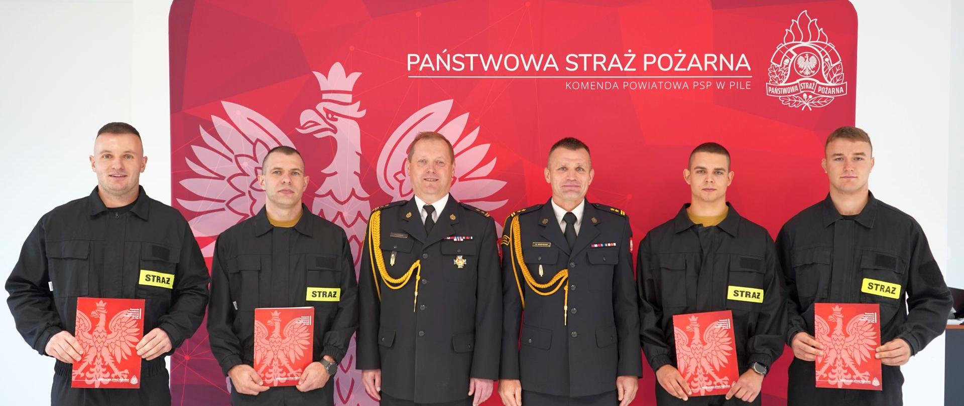 Na zdjęciu widnieją strażacy w trakcie uroczystości związanej ze ślubowaniem. 