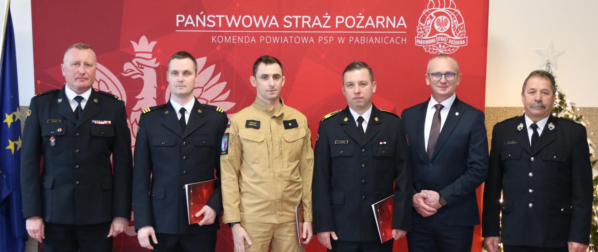 Zdjęcie wykonane podczas spotkania wigilijnego w Komendzie Powiatowej PSP w Pabianicach. Na zdjęciu awansowani na wyższe stopnie służbowe i zaproszeni goście.