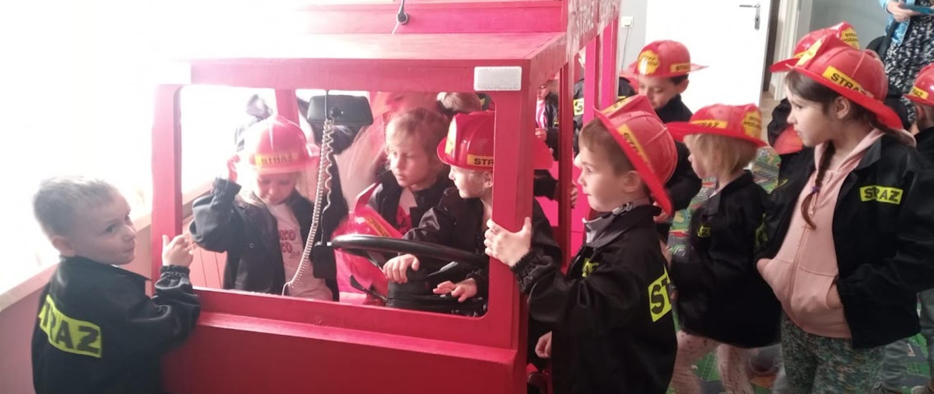 Przedszkolaki przy makiecie samochodu gaśniczego podczas zajęć w sali edukacyjnej "OGNIK" w Komendzie Powiatowej PSP w Bielsku Podlaskim. 