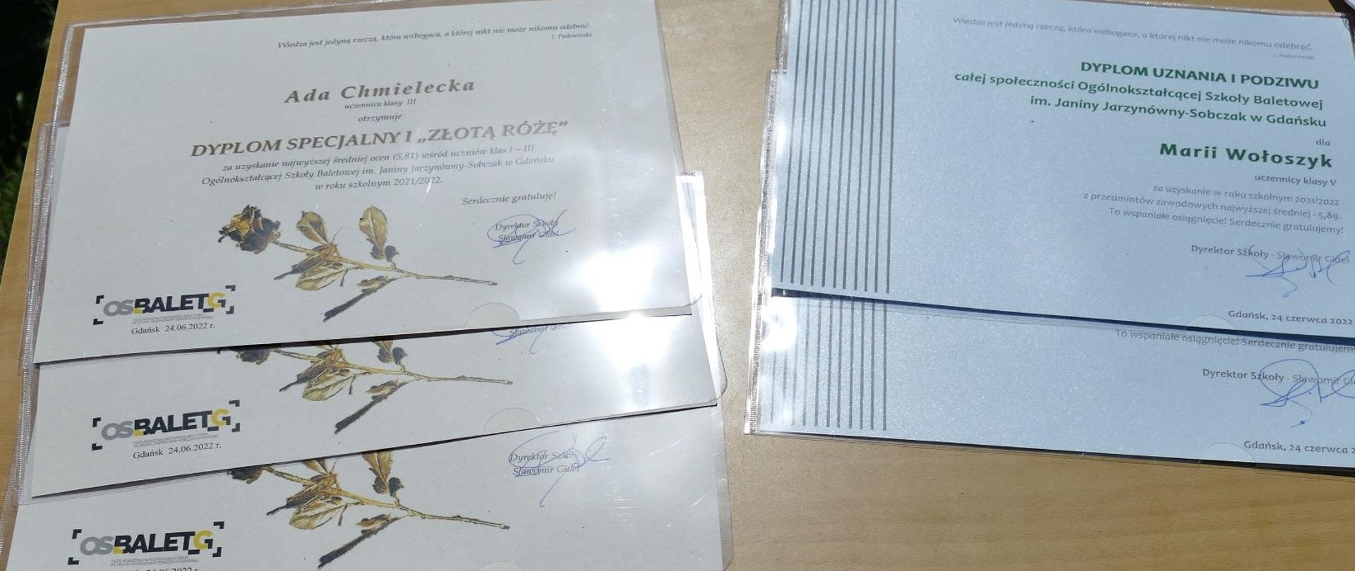 Dyplomy dla najlepszych uczniów 5 szt leżące na stole, 