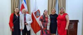 Grupo de 5 personas, en el fondo las banderas de Polonia y Costa Rica.