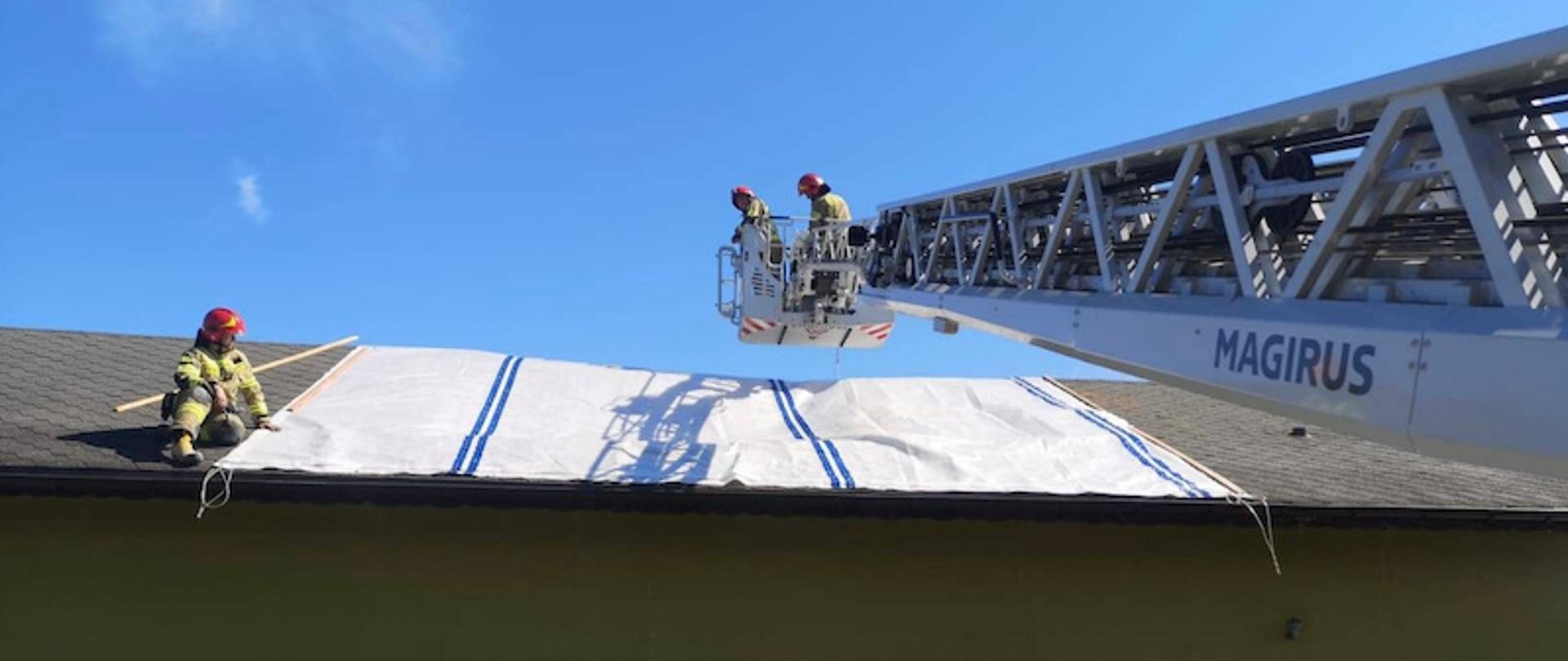 Strażacy zabezpieczają spalony dach