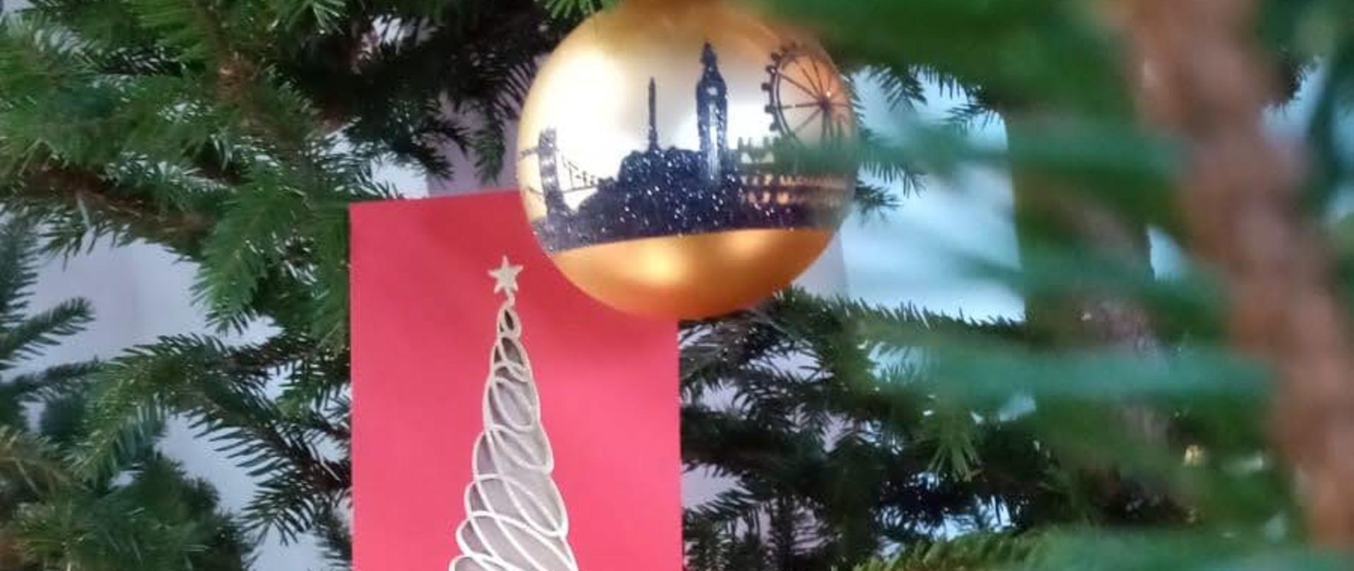 na zdjęciu znajduje się choinka jedna bombka oraz ozdoba choinkowa.