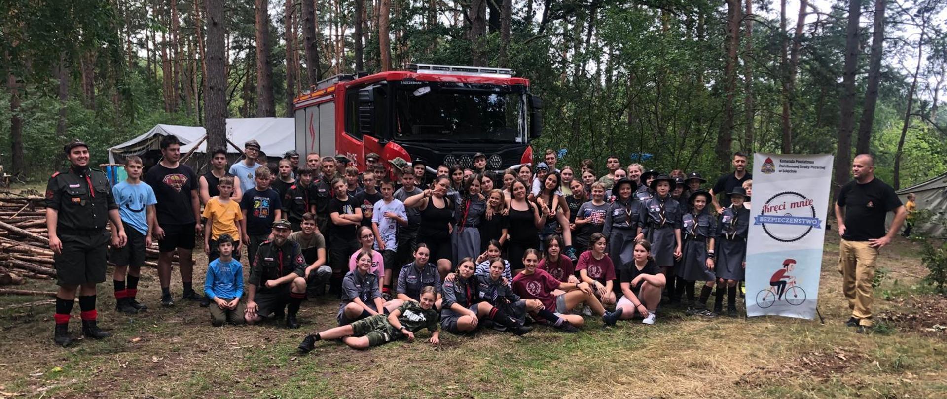 Zdjęcie grupowe grupy harcerzy na tle samochodu strażackiego