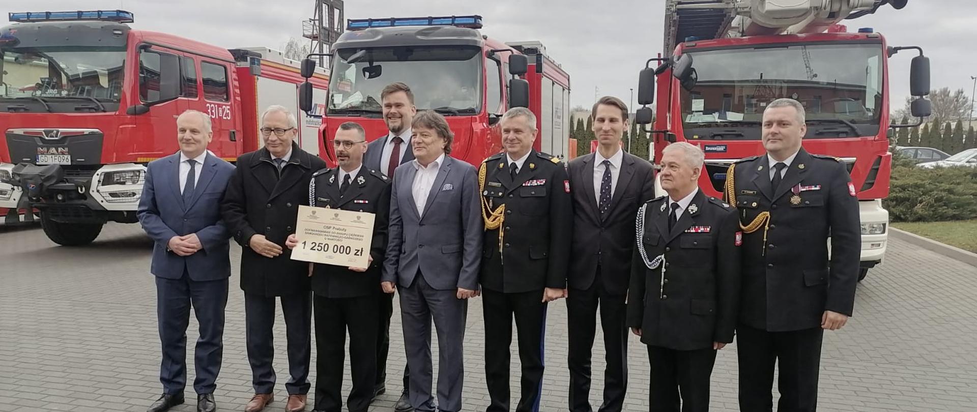 Na zdjęciu uczestnicy uroczystej zbiórki w trakcie wręczania promes na zakup pojazdów do OSP