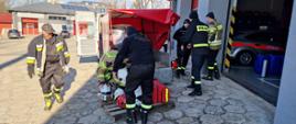 Funkcjonariusze Komendy Powiatowej PSP w Starachowicach przygotowujący sprzęt pożarniczy do wysłania dla strażaków z Ukrainy