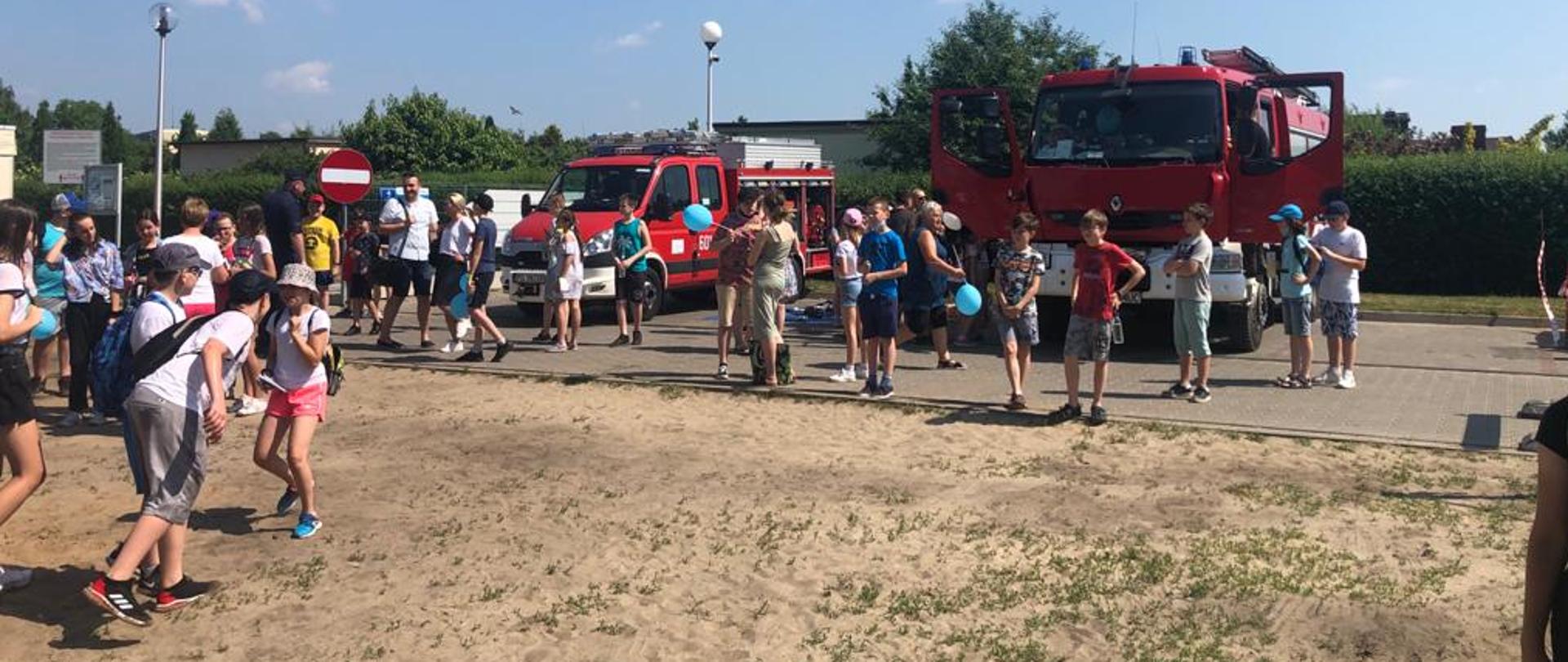 Samochody ratowniczo gaśnicze JRG Śrem i młodzież na plaży miejskiej w Śremie 