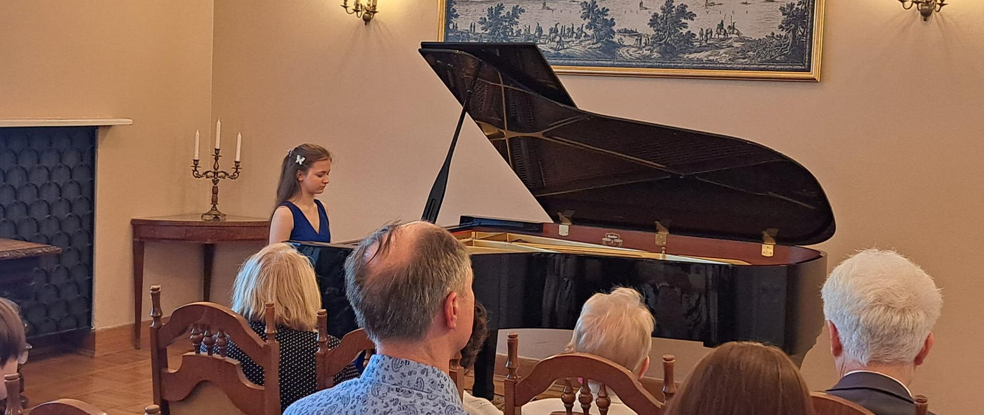 Laureatka konkursu siedzi przy fortepianie 