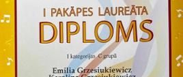 Dyplom XII Międzynarodowy Konkurs Małej Kameralistyki w Marupe/Łotwa - Dyplom laureata I miejsca dla Emilii i Karoliny Grzesiukiewicz, nauczyciel Agnieszka Zadroga. Żółte ramki plakatu z nutkami.