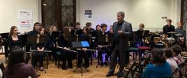 Zdjęcie przedstawia Big Band POSM II stopnia podczas występu w holu Pałacu Radolińskich oraz zgromadzoną publiczność podczas koncertu.