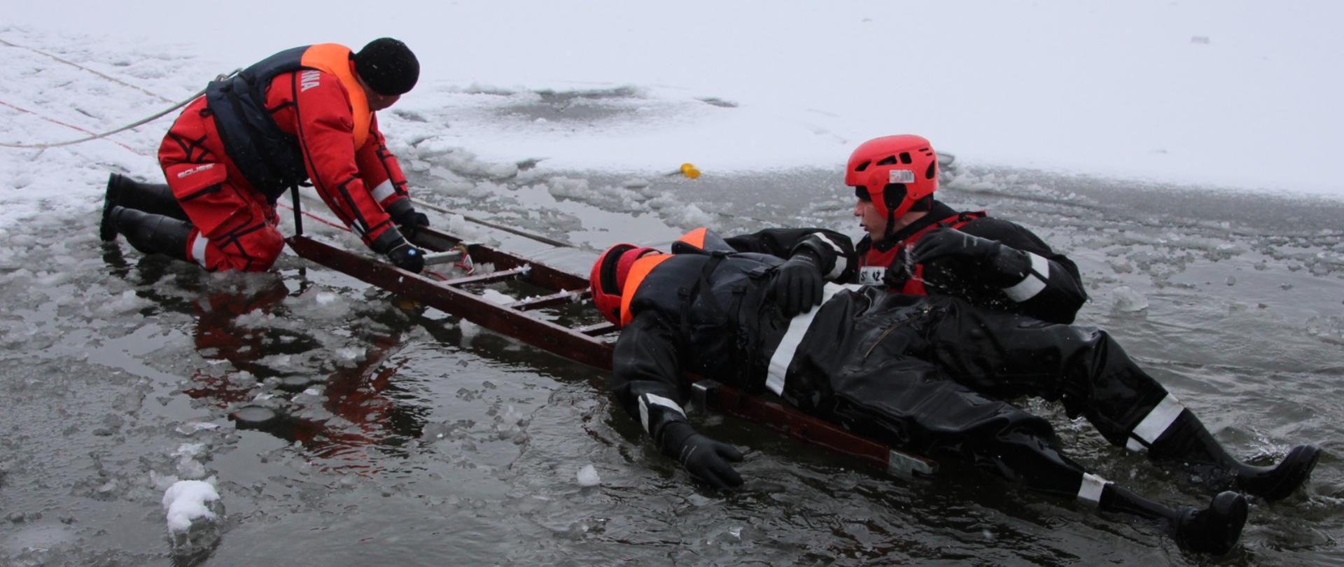 Zdjęcie przedstawia ćwiczących strażaków podczas ćwiczeń na lodzie