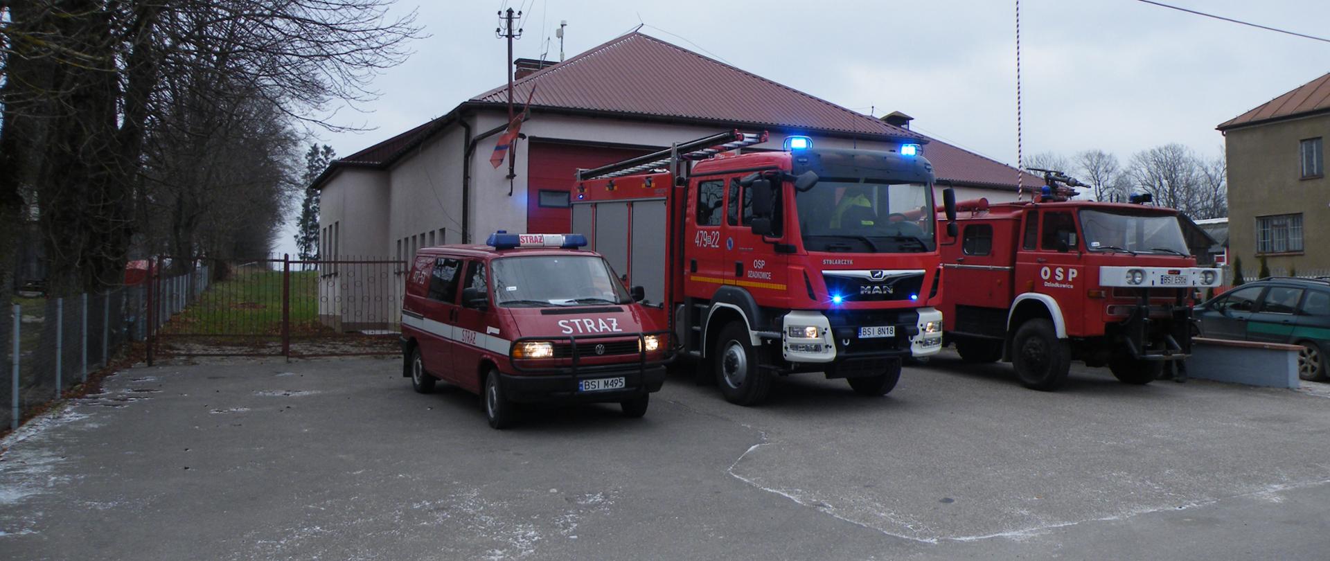 Zdjęcie strażnicy OSP w Dziadkowicach. Przed garażem stoją trzy pojazdy ratowniczo-gaśnicze.